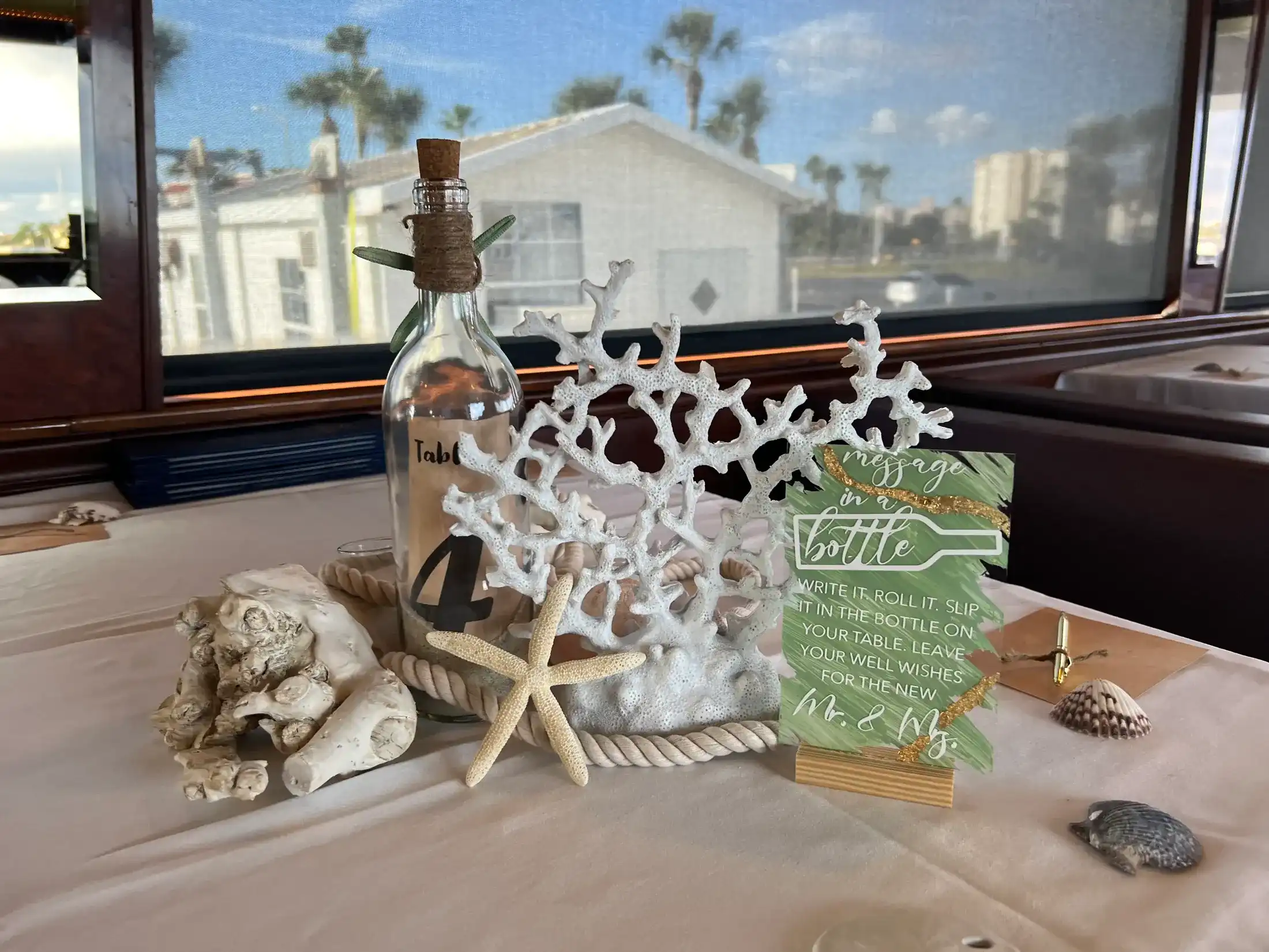 A coastal tablescape with coral, shells, rope and a message-in-a-bottle card
